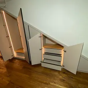 Einbauschrank unter Dachschräge mit LED-Beleuchtung und Schubladen offen