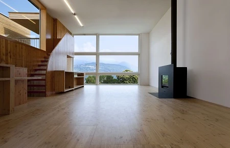 Moderner Wohnraum mit Holztreppe, Kamin und Panoramafenster mit Seeblick